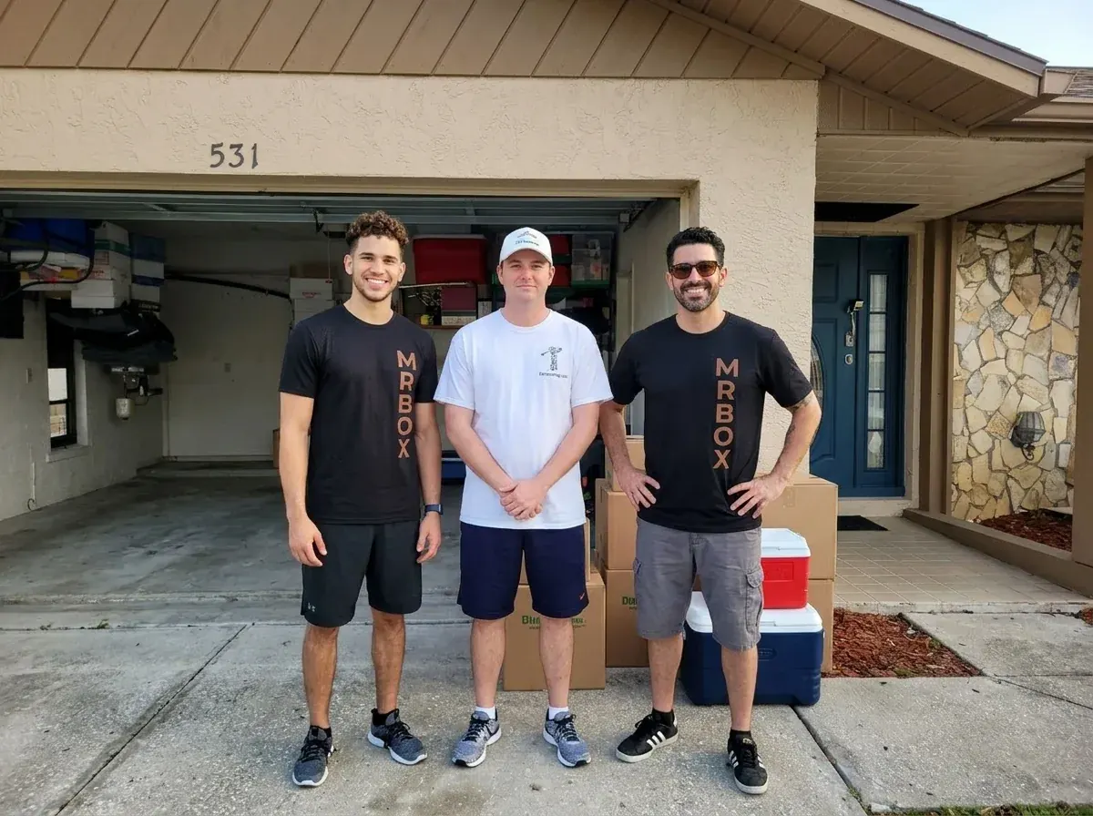 A customer standing between two Mr. Box movers outside a garage