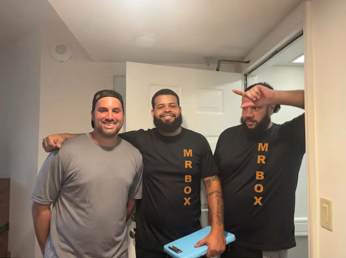 A customer and two Mr. Box movers posing together in a doorway