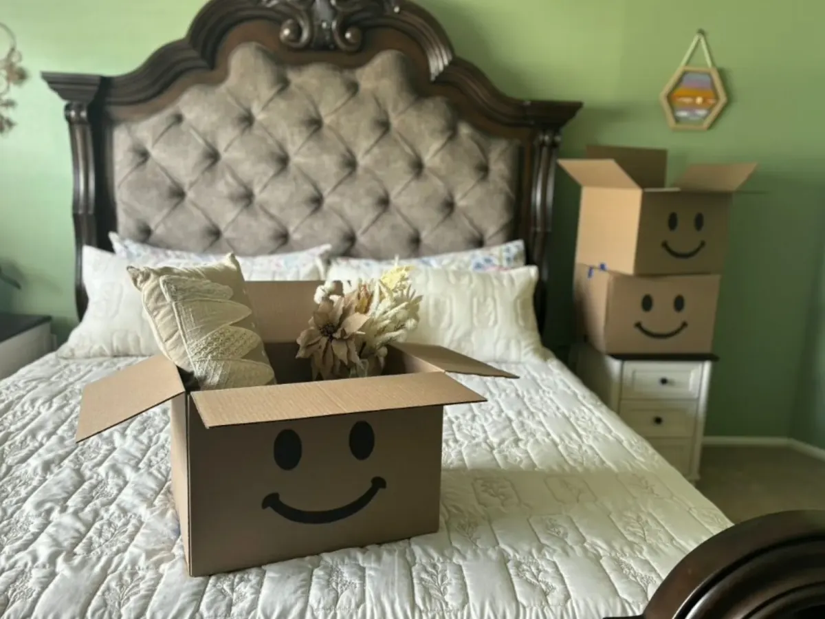 Smiling moving boxes carefully packed in a bedroom
